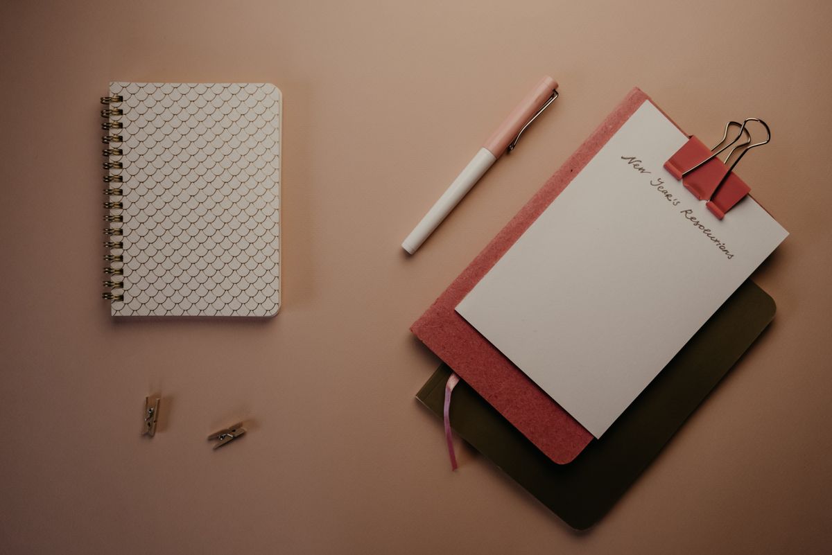 Notebooks and a habit tracker on a desk